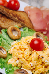 Scrambled eggs with white mushrooms and cherry tomatoes
