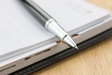 Naklejka premium Fountain pen in a notebook