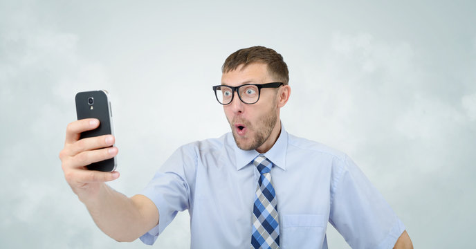 Funny businessman photographing himself on a smartphone