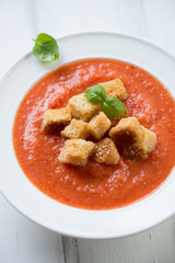 Gazpacho with croutons in a glass plate, close-up, vertical shot