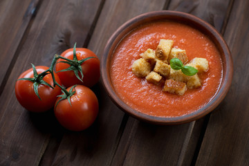 Ceramic bowl with Gazpacho over rustic wooden background