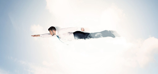 Business man flying like a superhero in clouds on the sky