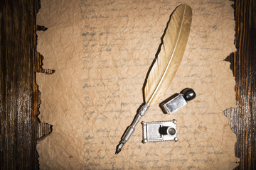 Vintage golden pen and ancient manuscripts