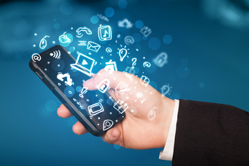 Hand holding smartphone with media icons and symbol