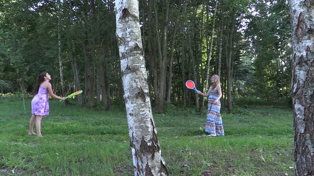 girl play badminton shuttlecock green park with pregnant woman