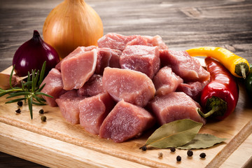 Raw pork chops on cutting board and vegetables
