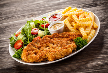 Fried pork chop, boiled potatoes and vegetable salad