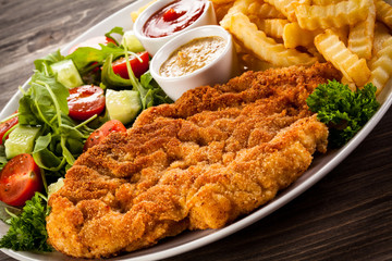 Fried pork chop, boiled potatoes and vegetable salad