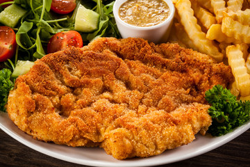Fried pork chop, boiled potatoes and vegetable salad