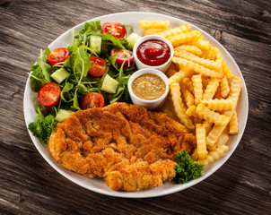 Fried pork chop, boiled potatoes and vegetable salad