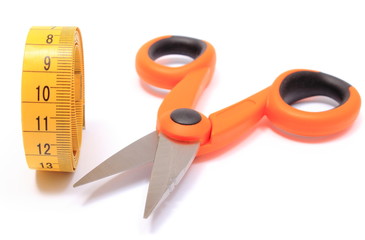 Scissors with tape measure on white background