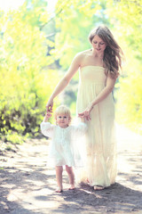 Sunny photo mother and child walking barefoot in the forest