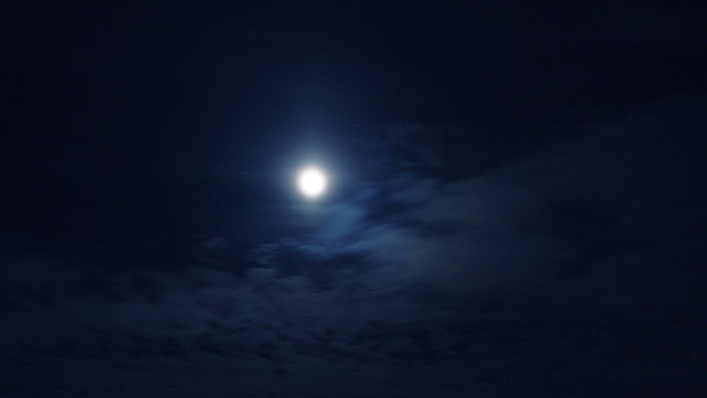 Full moon in dark night cloudy sky time-lapse