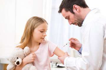 Young little girl  being vaccinated at the doctor