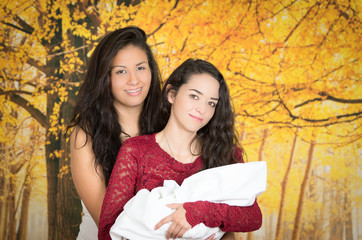 portrait of beautiful lesbian couple holding their baby