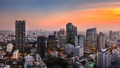 Fototapeta na wymiar Bangkok city sunlight warm orange panorama, dawntime sunrise in morning rooftop view, the office buildings in Bangkok city skyline top view business office in capital city of Thailand Asian