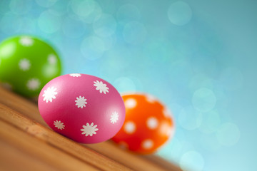 Colored Easter eggs and flowers on blue background