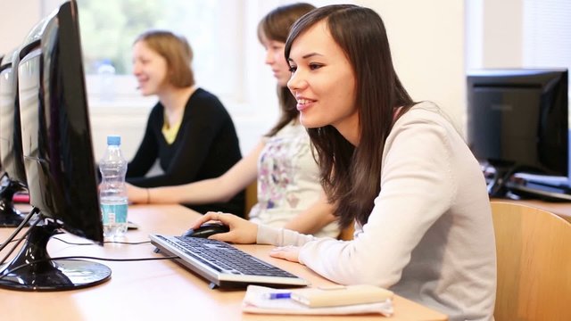 College students sitting in a classroom, using comput