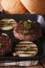 grilled burgers with onion and garlic on the grill. vertical