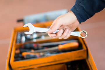 Mechanic hand holding a wrench