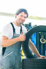Mechaniker bei Reifenwechsel in Autowerkstatt