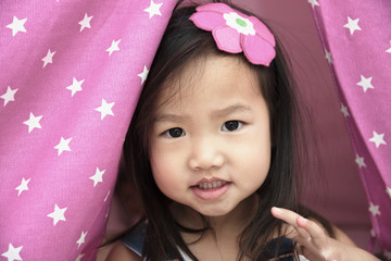 Female toddler portrait with pink fabric