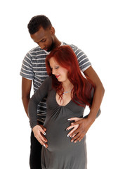 Man standing behind pregnant wife.