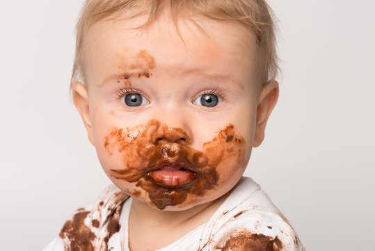 Kleines Baby mit Schokolade verschmiert