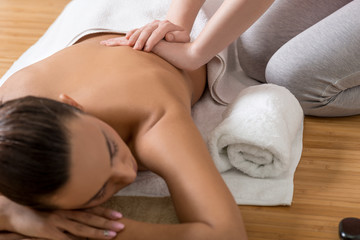 Fototapeta na wymiar Woman Receiving Back Massage in Spa Center