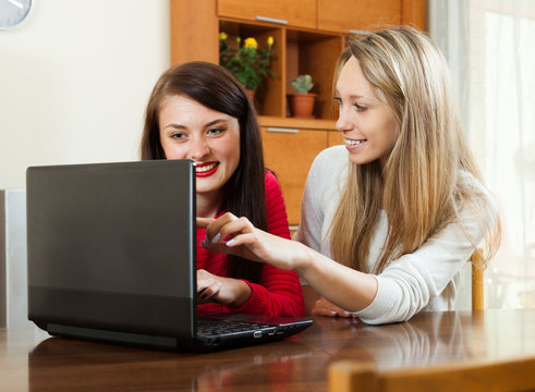 women looking to laptop at table