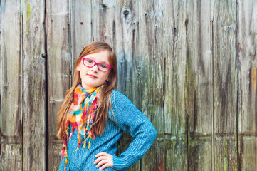 Fototapeta premium Outdoor portrait of a cute little girl in glasses