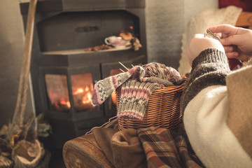 Obraz premium Gemütlich vor dem Kamin stricken
