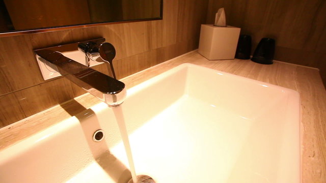 Motorized dolly shot of water faucet in a luxurious hotel room