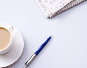 Cup of coffee near newspapers, pen