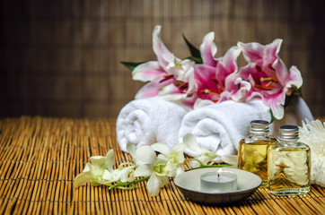 Fototapeta na wymiar Towels, oil, candle, flowers for spa treatment