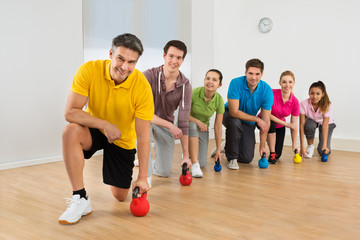 Mature Fitness Instructor With People Exercising