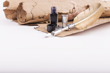 Vintage golden pen and ancient manuscripts on a white background