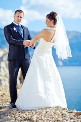 groom and bride walking on a beach