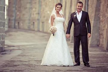 Naklejka premium Groom and bride are walking in old town