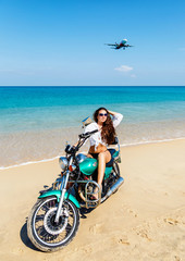 Obraz premium Young sexy girl in a bathing suit on a beach with the motorcycle