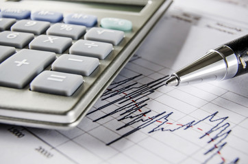 Stock exchange graph with calculator and pen