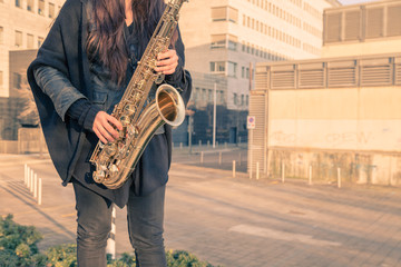 Beautiful young woman playing tenor saxophone