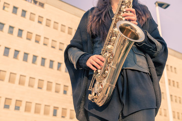Beautiful young woman playing tenor saxophone