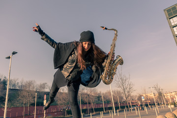 Beautiful young woman with her saxophone