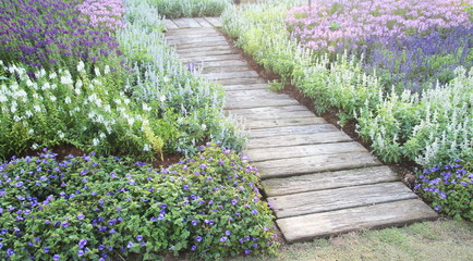 Brown chair in a flowers garden with walkway