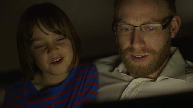 Father and daughter enjoying a movie on tablet