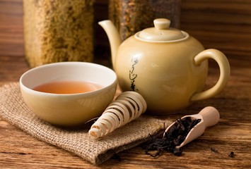 Fototapeta na wymiar Tea set on wooden board and spoon with dry tea leafs