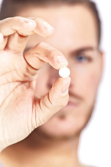 close-up of pills showed by a handsome man, isolated on white