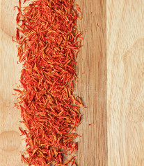 bright saffron spice on wooden kitchen plank background