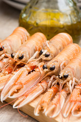 Scampi crudi sul tagliere di legno